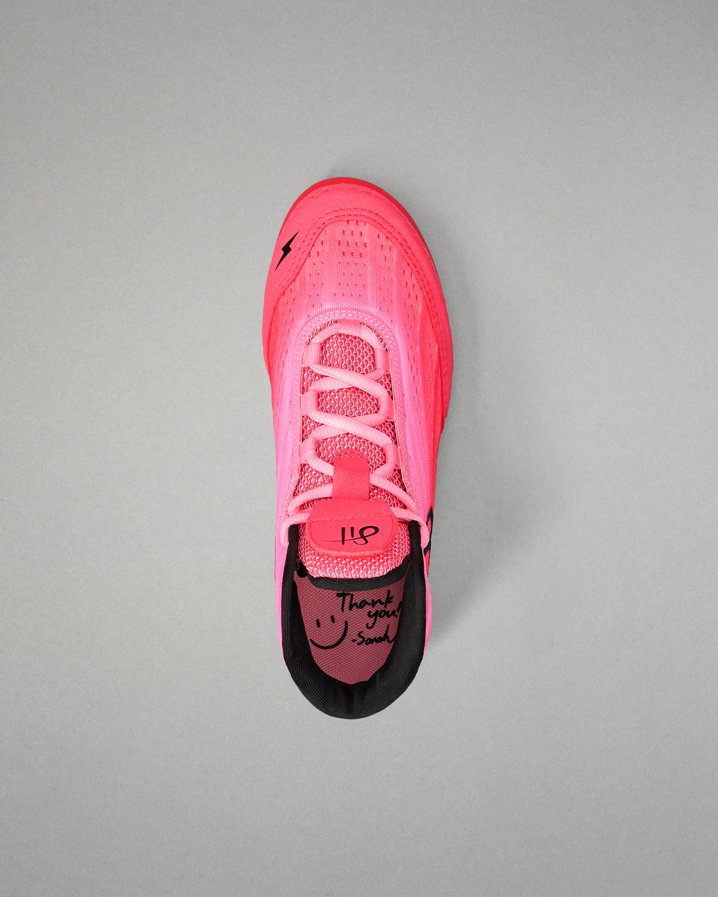 Pink wrestling shoe with black sole on a gray background