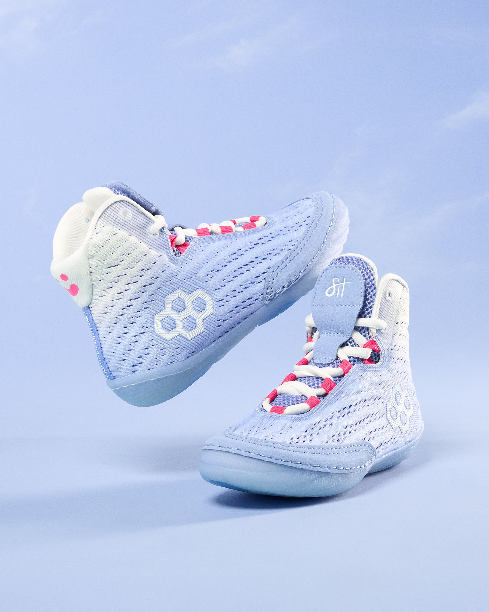 Light blue wrestling shoes with colorful laces on a light blue background