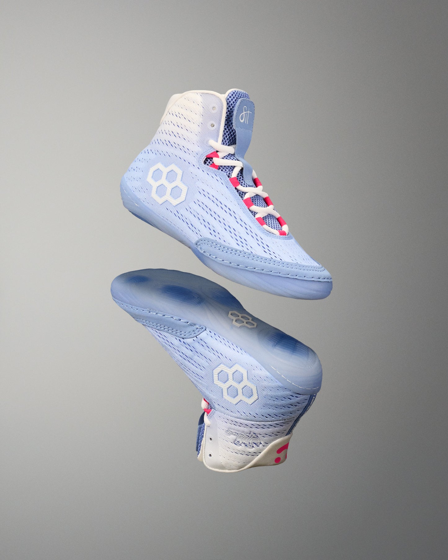 Light blue wrestling shoes with white and pink accents on a gray background