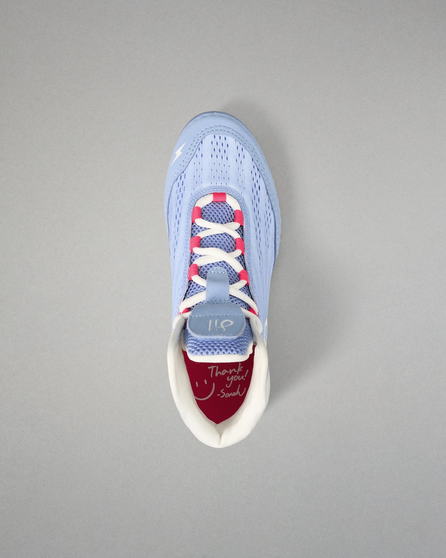 Light blue wrestling shoe with colorful sole on a gray background