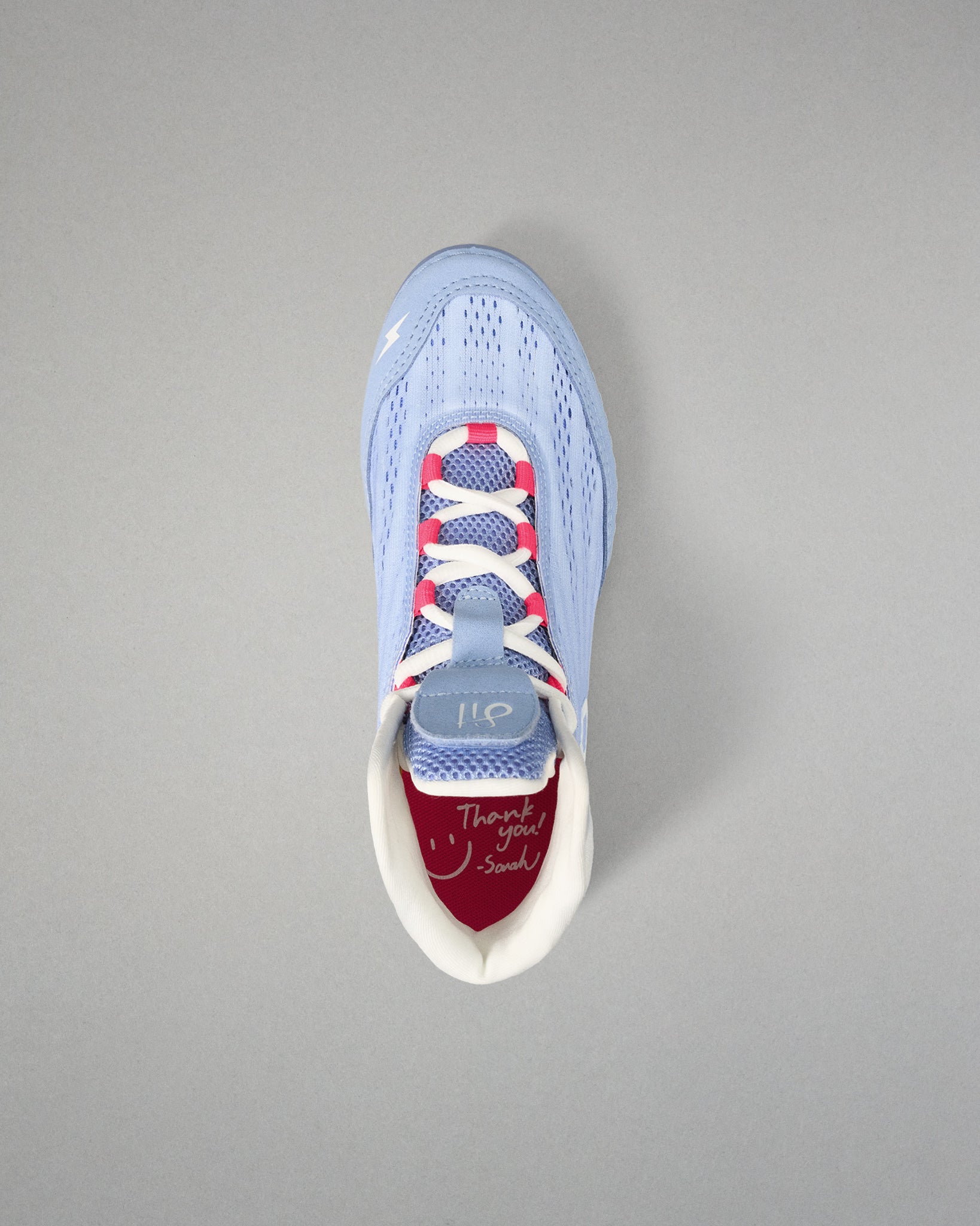Light blue wrestling shoe with colorful sole on a gray background