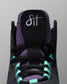 Close-up of a black sneaker with purple and teal accents on a gray background