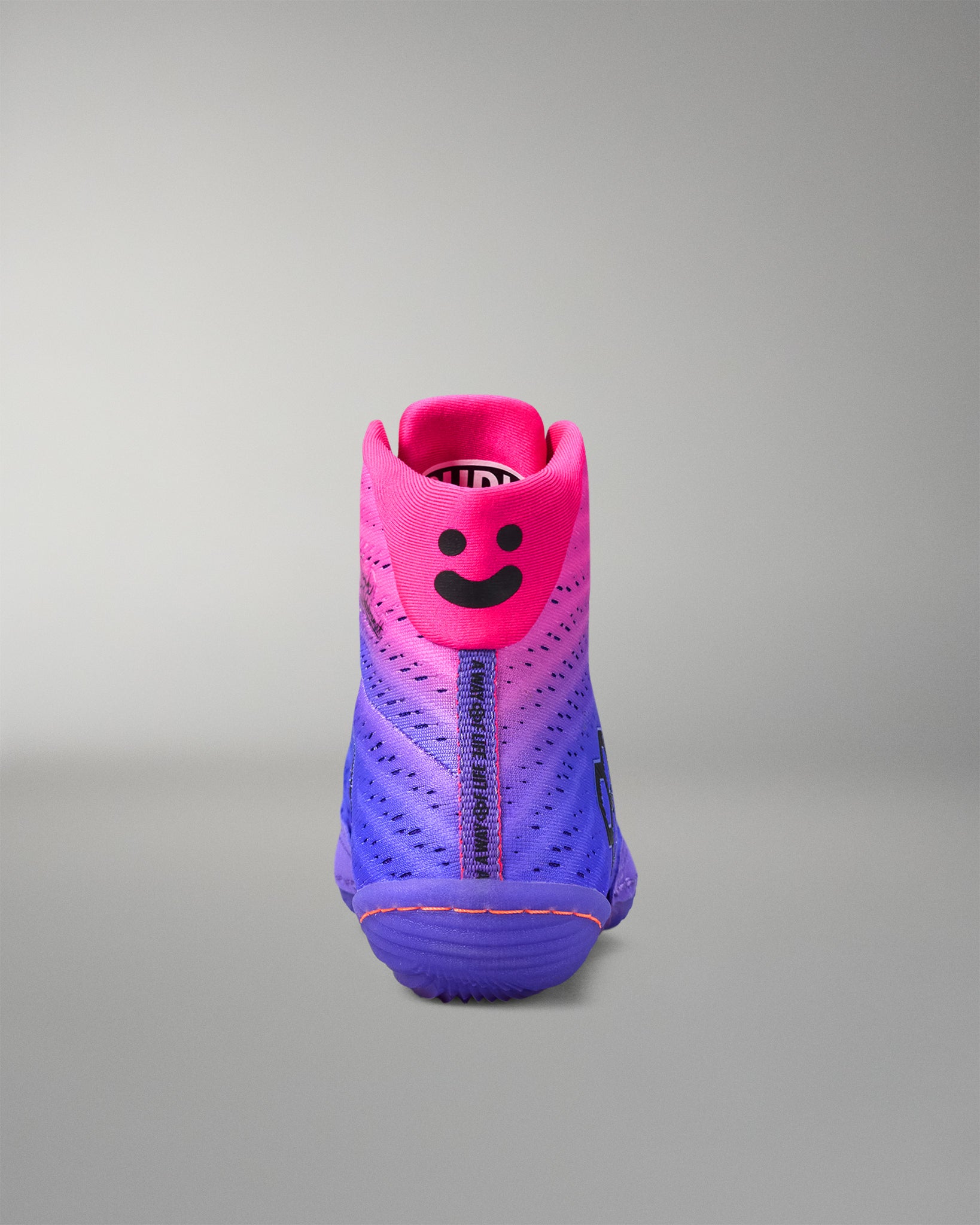 Pink and purple wrestling shoe with a gradient effect on a gray background