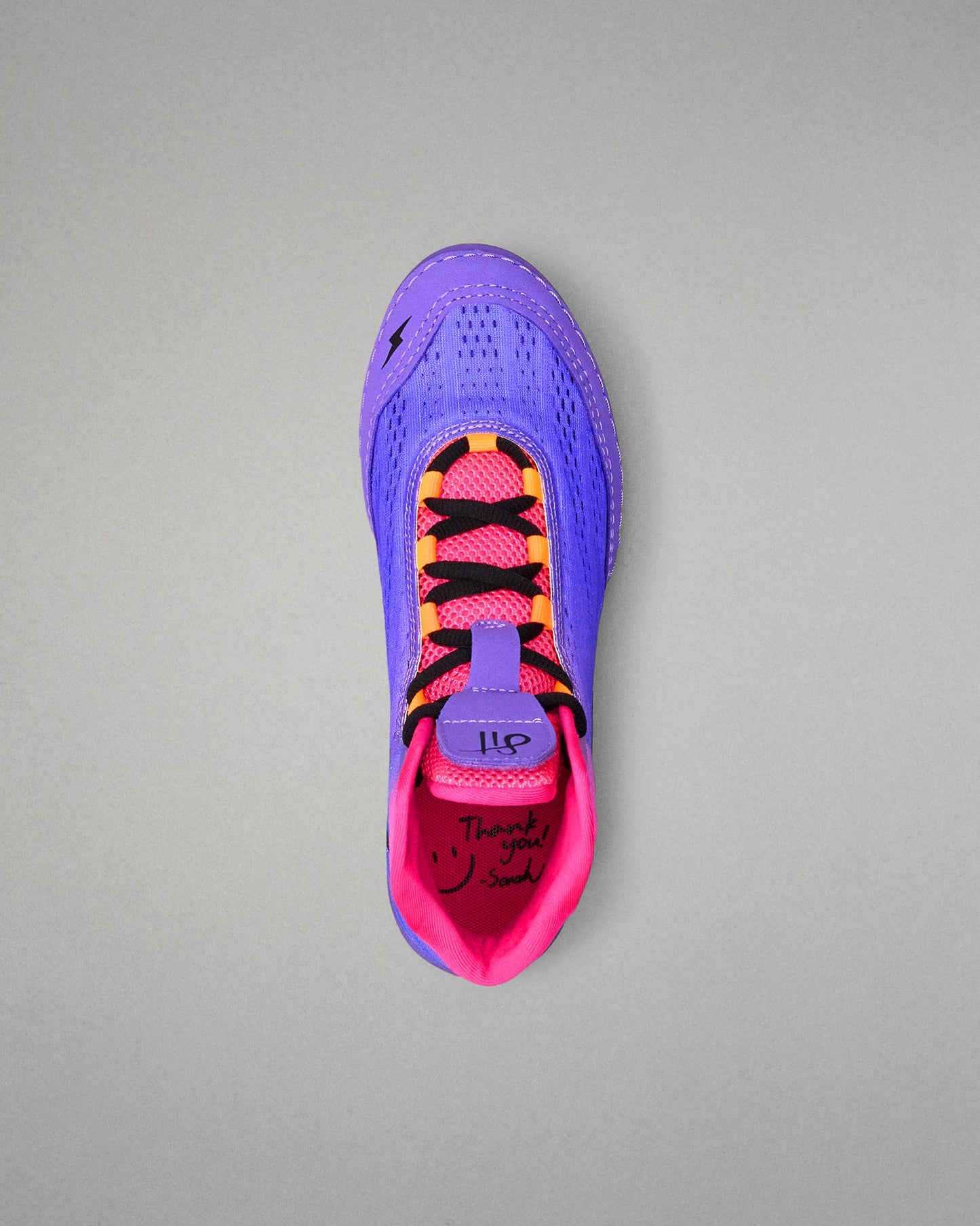 Purple and pink wrestling shoe with black accents on a gray background