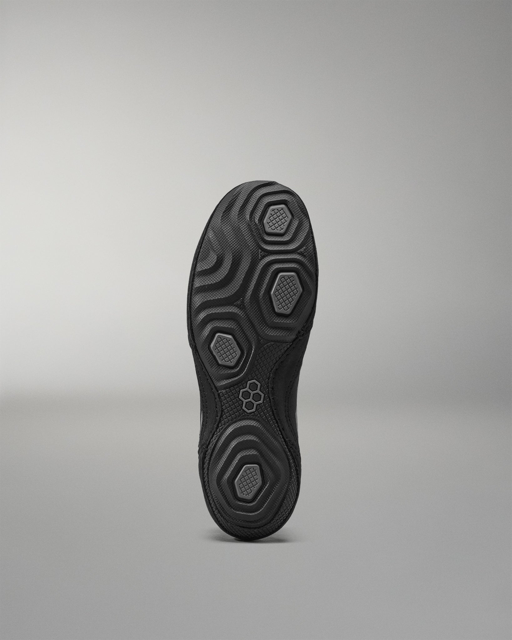 Black Wrestling Shoes sole with textured pattern on a gray background