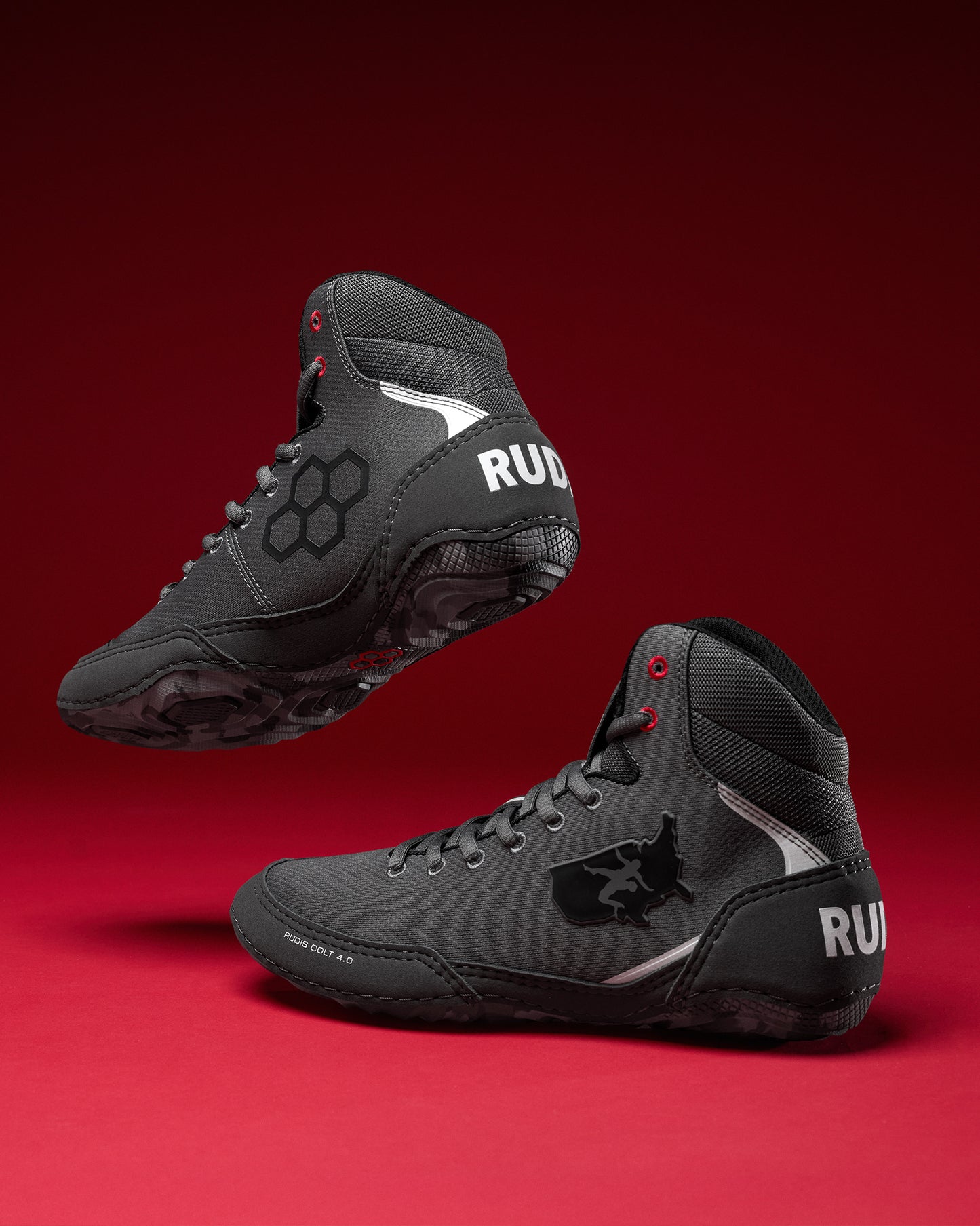 Pair of gray wrestling shoes with 'RUDIS' and 'USA Wrestling' branding on a red background