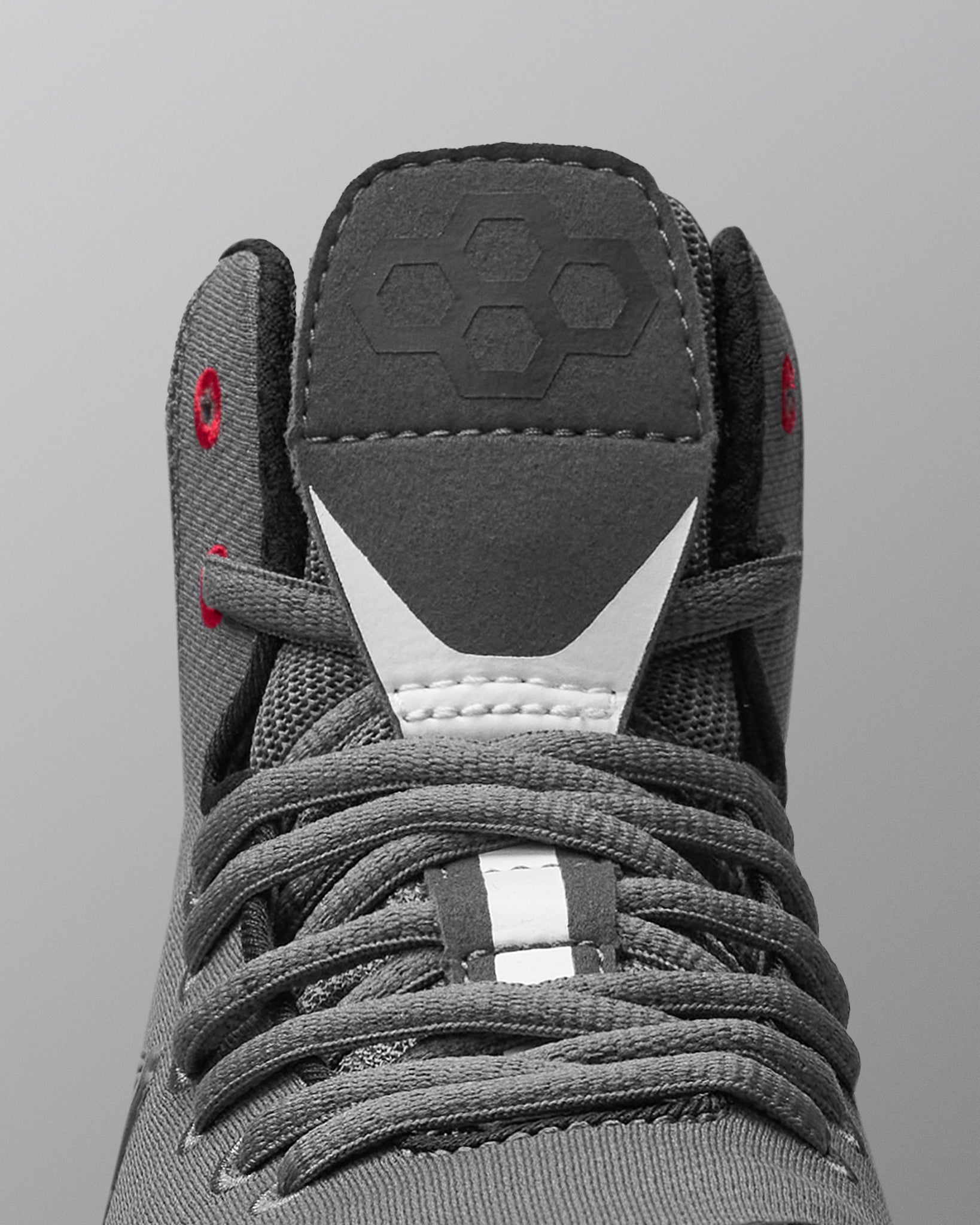 Gray wrestling shoe with laces on a gray background