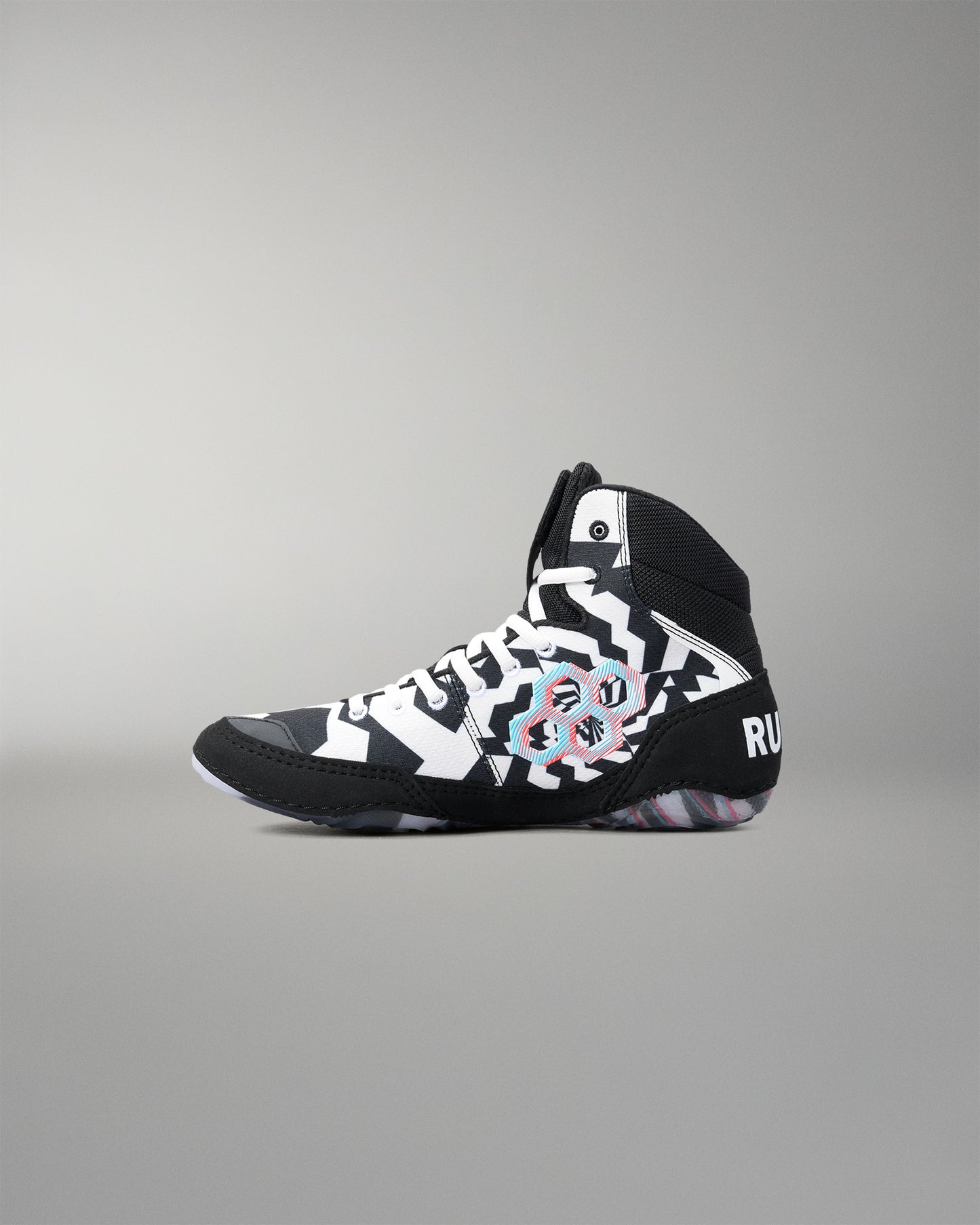 A high-top athleticwrestling shoe in black, white, and gray with a colorful abstract graphic on the side, shown against a neutral gray background.