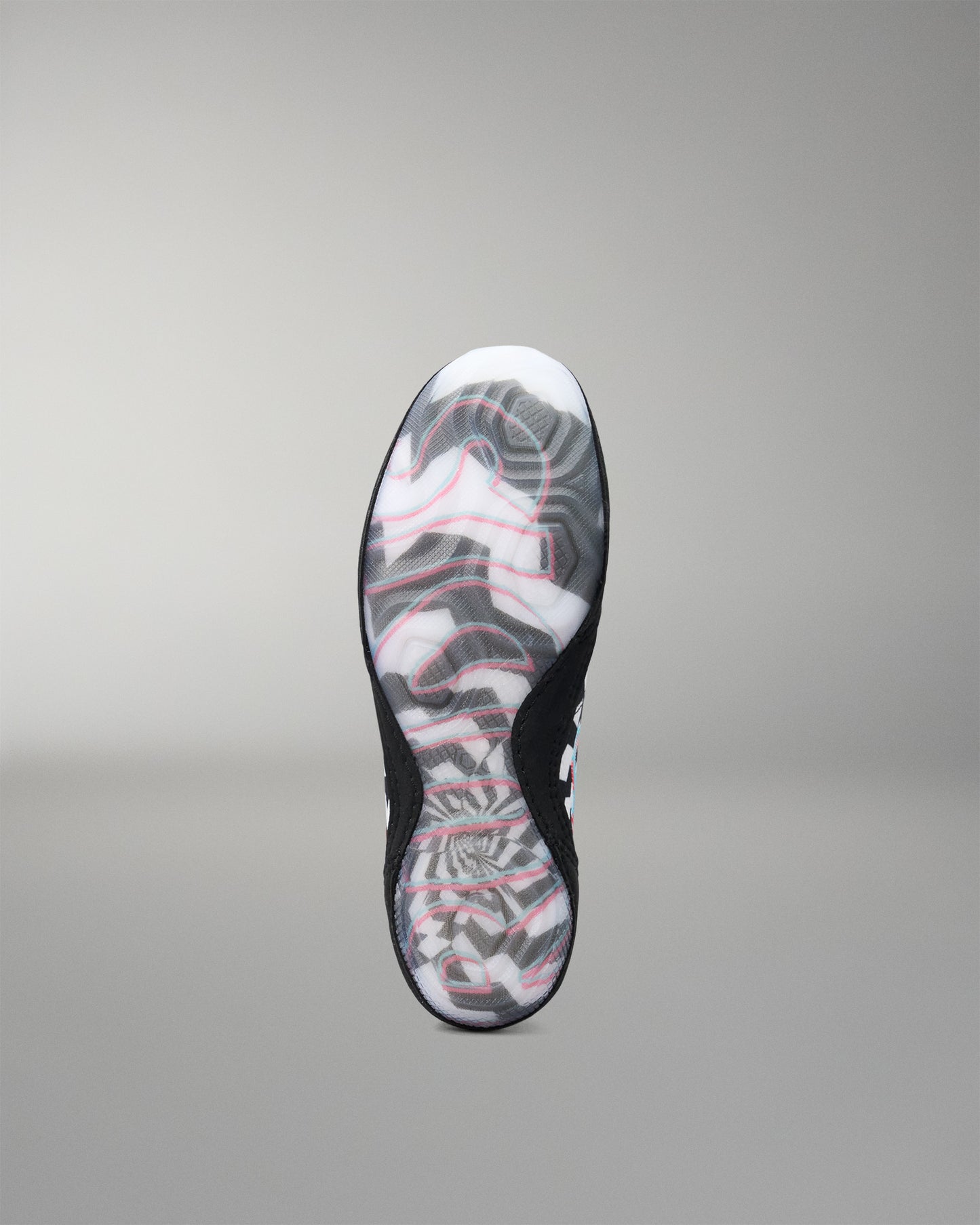 A single wrestling shoe shown from the sole view, featuring a black outsole with a white, gray, and pink abstract wavy pattern, set against a neutral gray background.