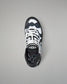 A single high-top wrestling shoe shown from a top-down view on a neutral gray background. The shoe features a black and white geometric pattern on the upper, white laces, and a black collar with a white logo.