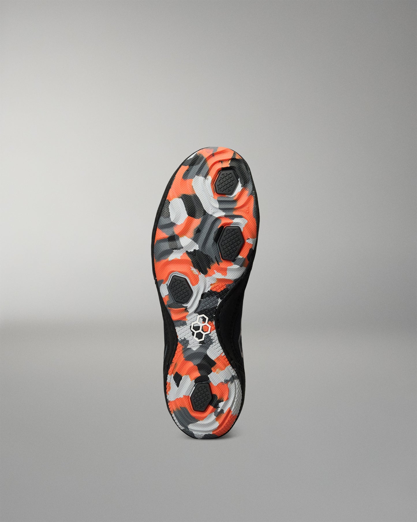 The outsole of a black Wrestling Shoe featuring a vibrant orange, gray, and black camouflage pattern, shown against a neutral gray background.