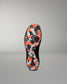 The outsole of a black Wrestling Shoe featuring a vibrant orange, gray, and black camouflage pattern, shown against a neutral gray background.