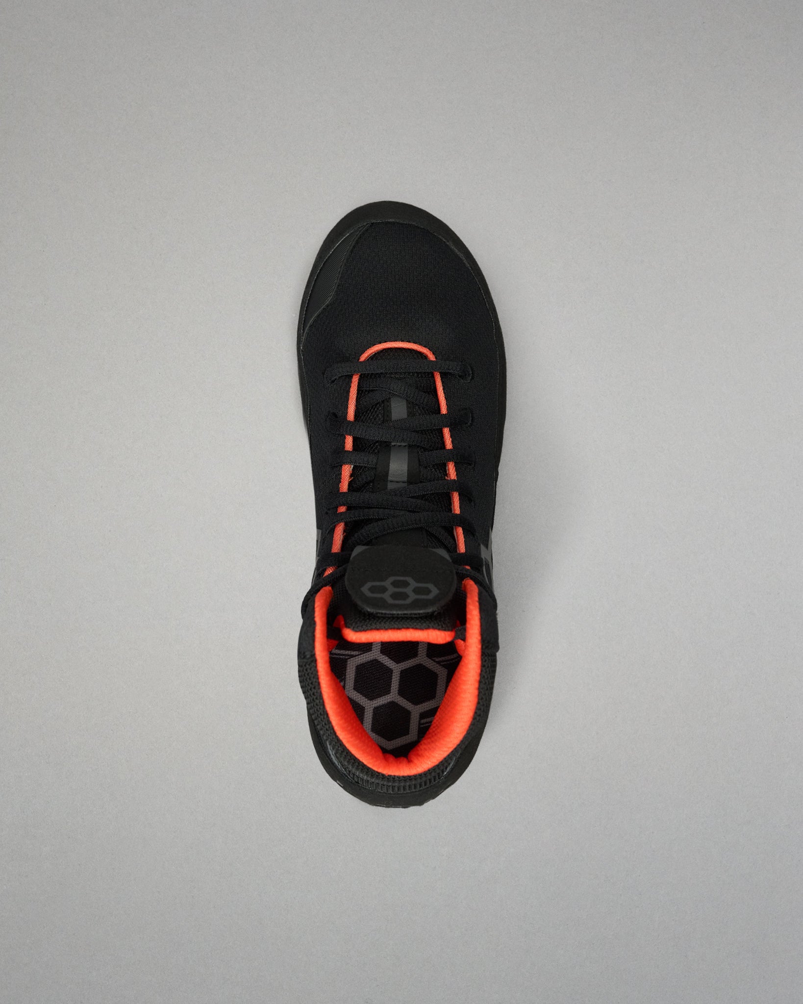 A black Wrestling Shoe with vibrant orange accents, shown from a top-down view on a neutral gray background.