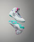 Pair of white and teal sneakers with pink accents on a gray background