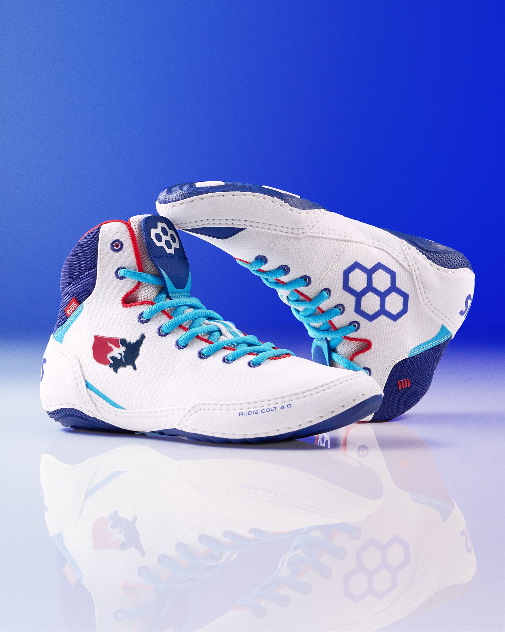 White USA Wrestling Shoes with blue and red accents on a reflective surface with a blue background