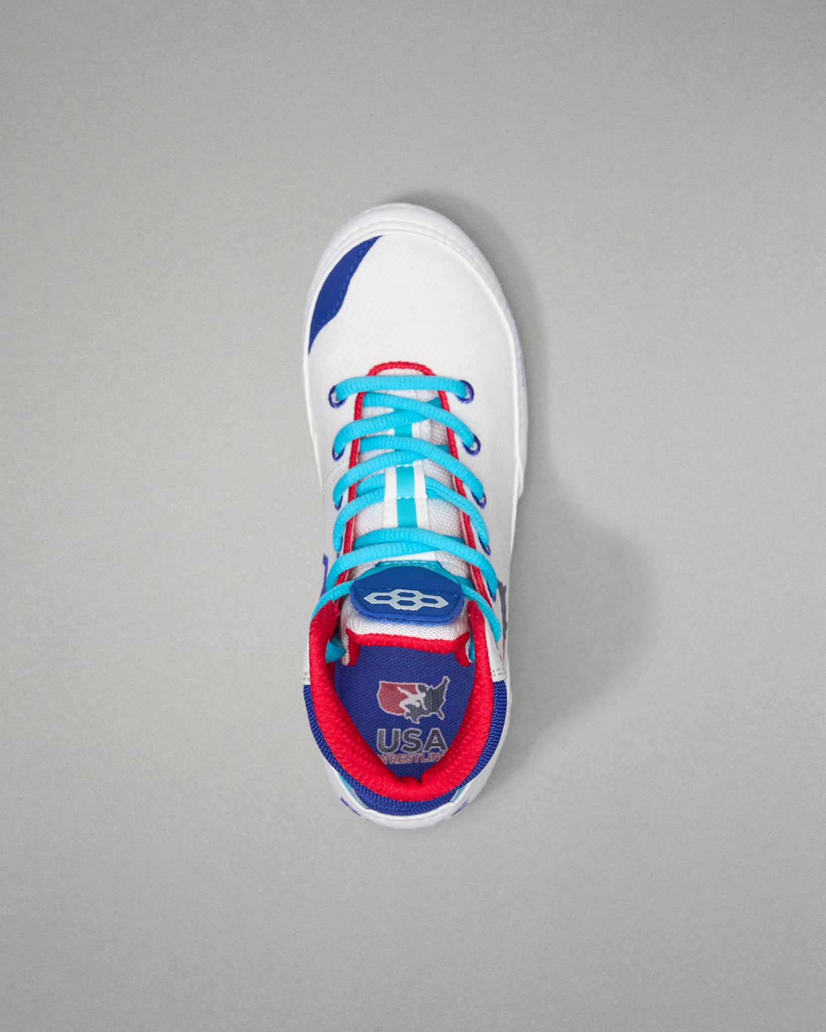 White USA Wrestling Shoes with blue and red accents on a gray background