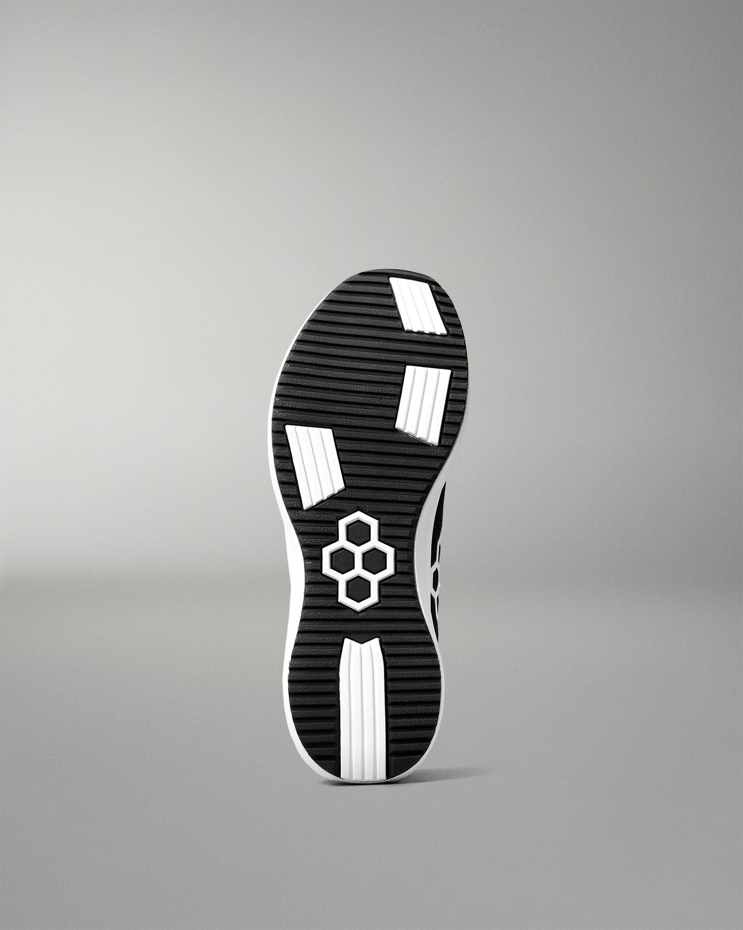 Black and white shoe sole with a brand logo on a gray background