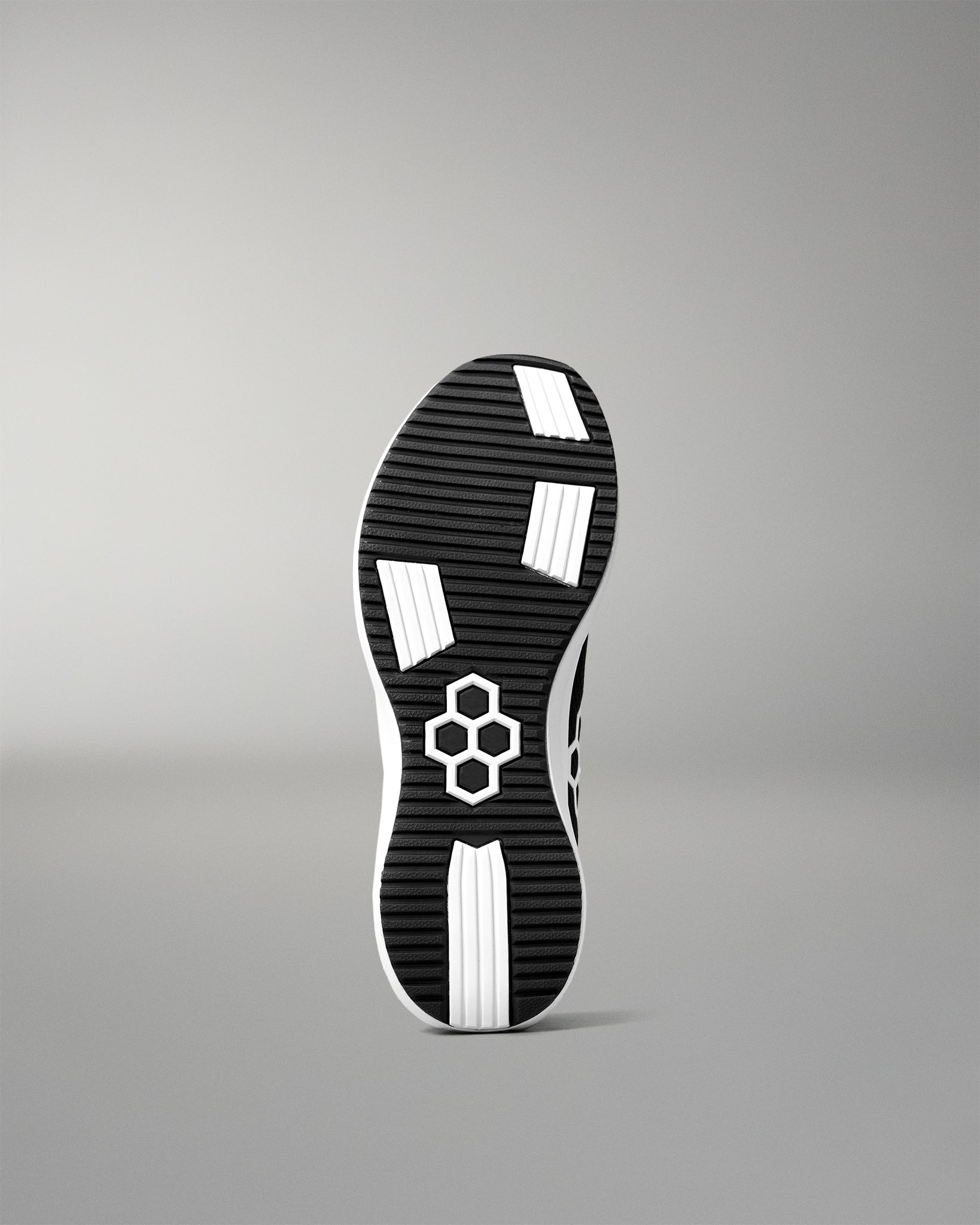 Black and white shoe sole with a brand logo on a gray background