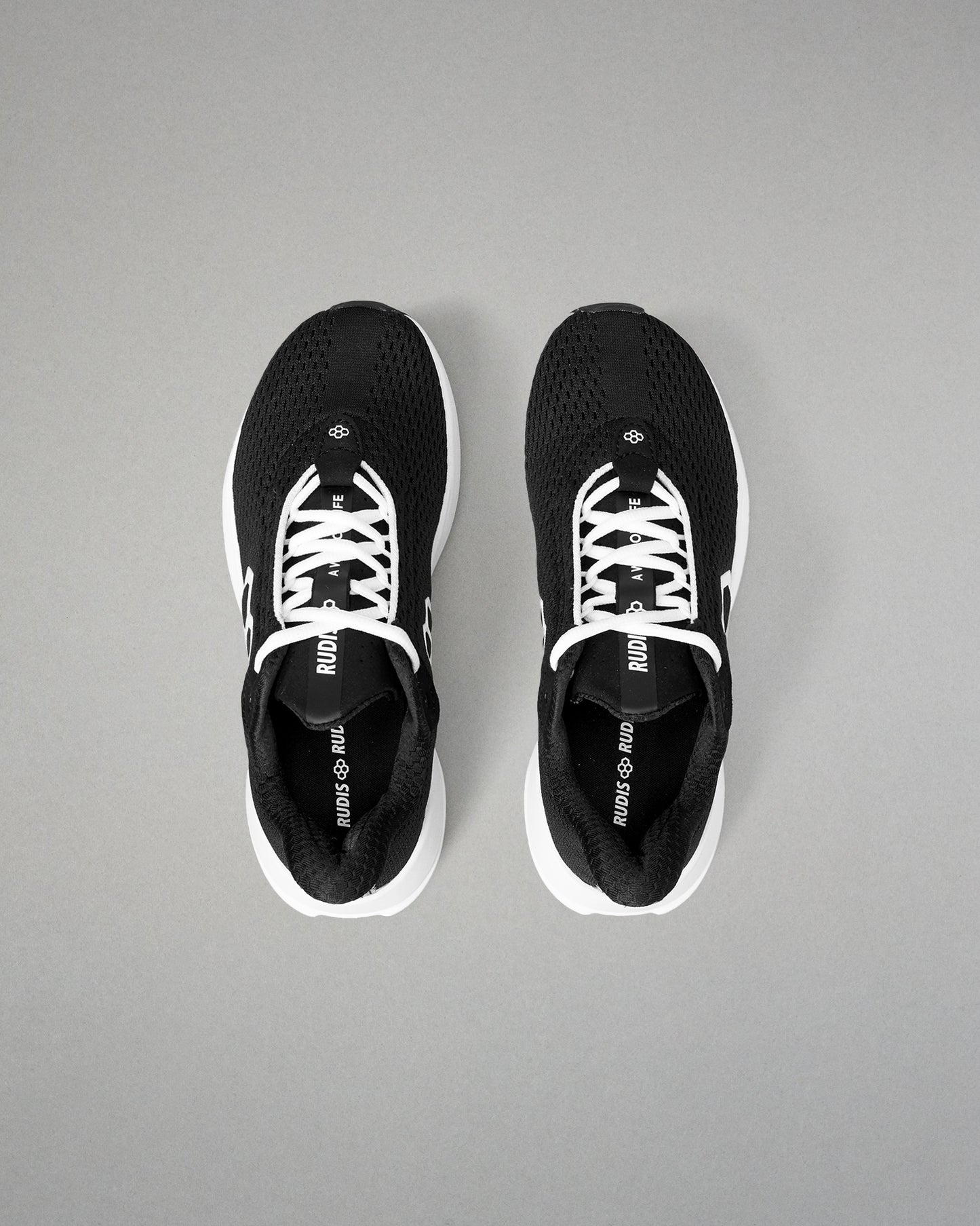 Black athletic shoes with white soles on a gray background