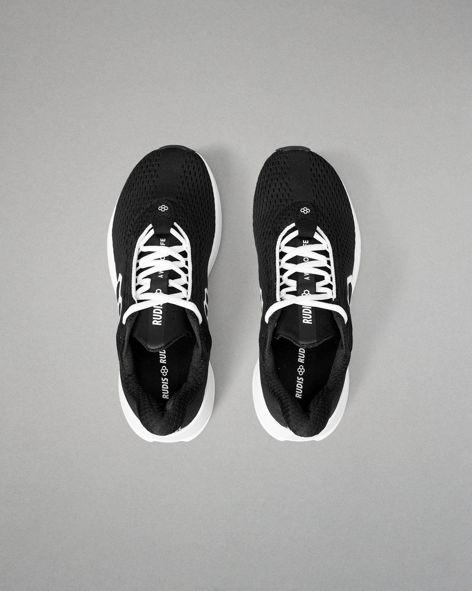 Black athletic shoes with white soles on a gray background