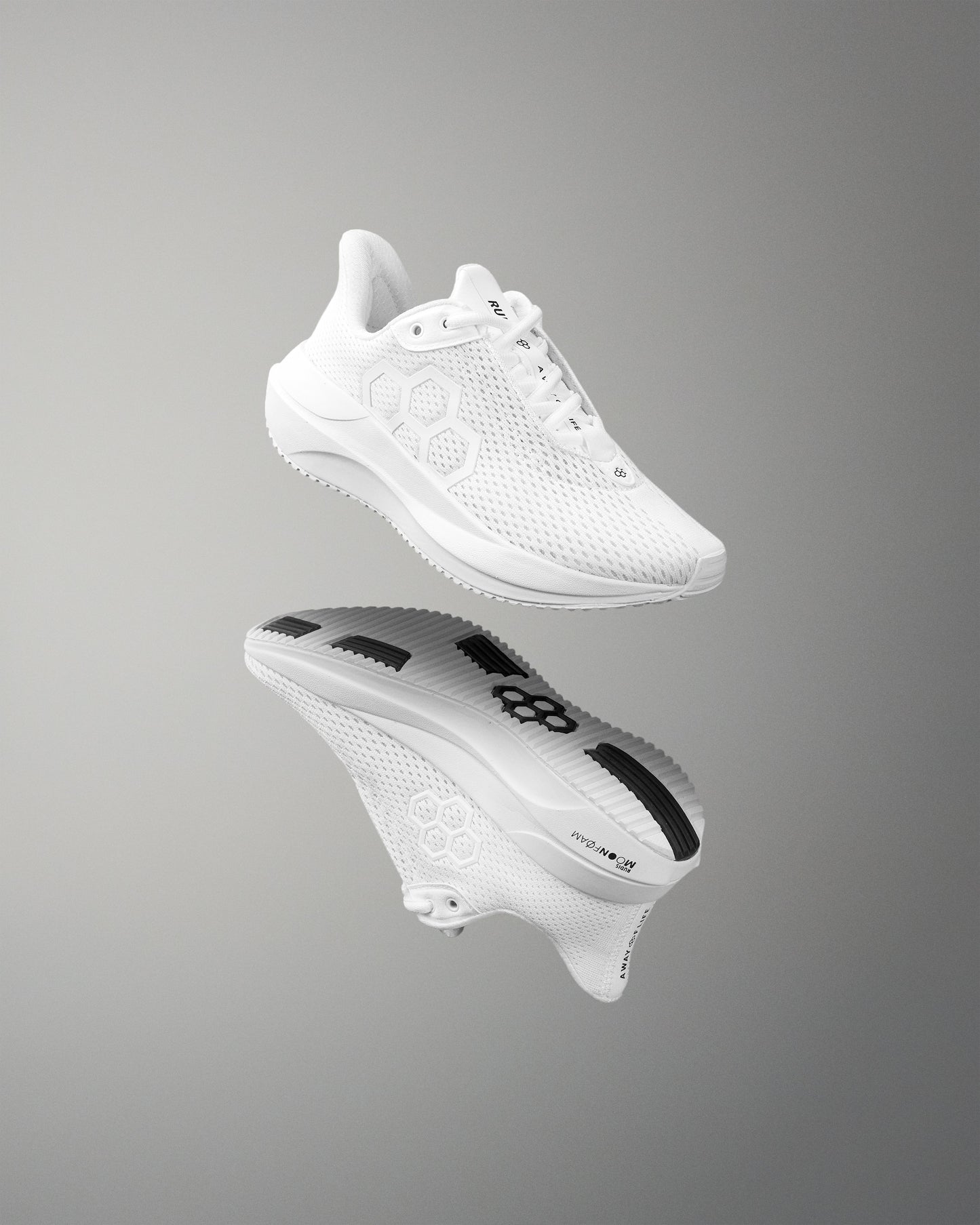 White athletic shoe with brand logo on a reflective gray surface