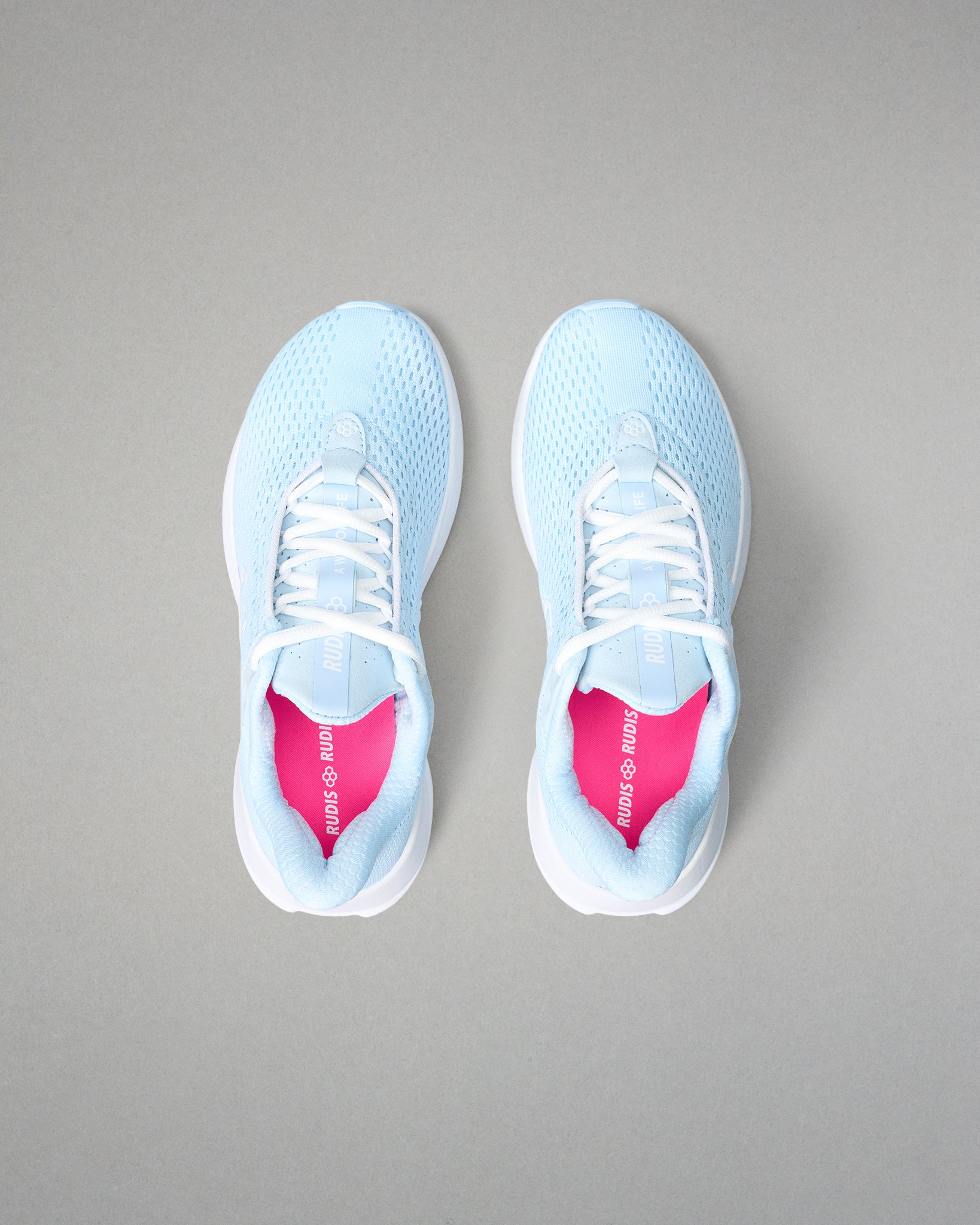 Light blue sneakers with white soles on a gray background