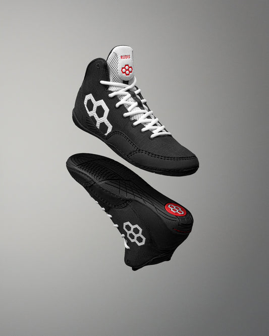Floating pair of RUDIS Courage 2.0 Youth Wrestling Shoes featuring a black upper, white laces, and durable outsole for youth wrestling performance.