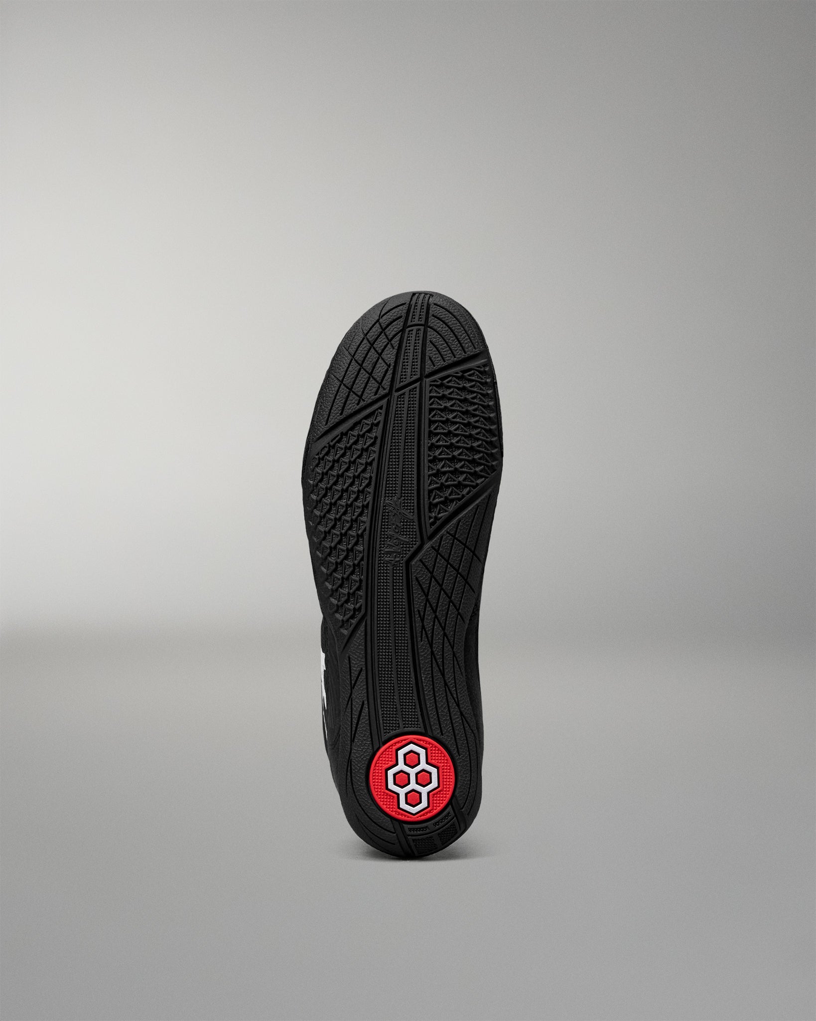 Bottom outsole of the RUDIS Courage 2.0 Youth Wrestling Shoe featuring a high-traction rubber tread with a red RUDIS logo pivot point.