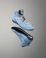 A pair of light blue high-top wrestling shoe shown floating against a gray gradient background, displaying both the side profile and the sole of the shoes.