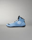 A light blue high-top wrestling shoe with white laces, a white geometric logo on the side, and black accents on the collar, tongue, and sole, shown against a neutral gray background.