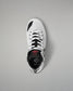 A white low-top wrestling shoe with black accents and white laces, shown from a top-down view on a neutral gray background. The brand name 'RUDIS' is visible on the black heel collar.