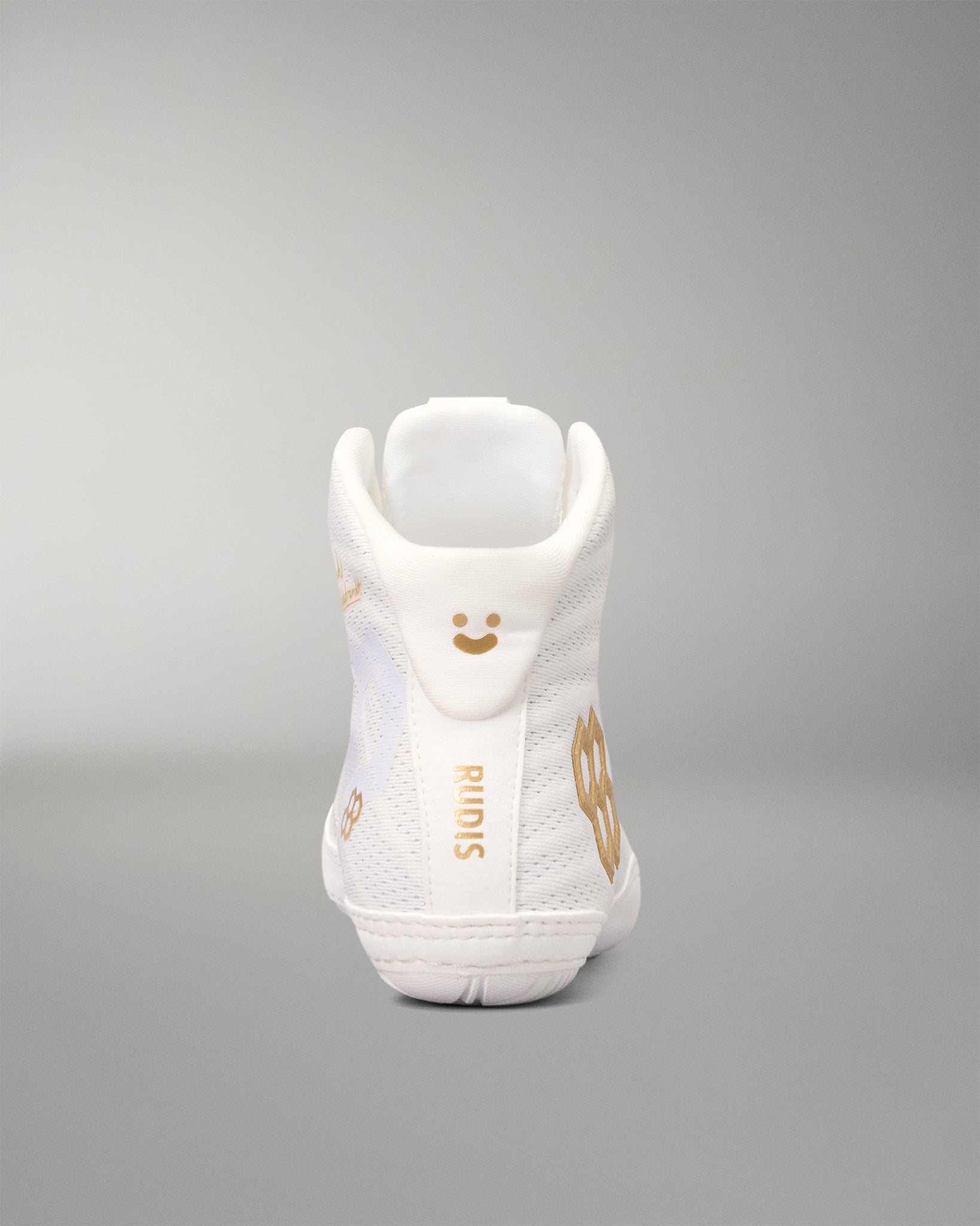 A white high-top wrestling shoe shown from the back, featuring gold-colored graphic details, including a smiley face, the brand name 'RIMIS', and a large gold number '8'.