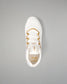 A white athletic wrestling shoe with gold accents and gold laces, shown from a top-down view on a solid gray background.