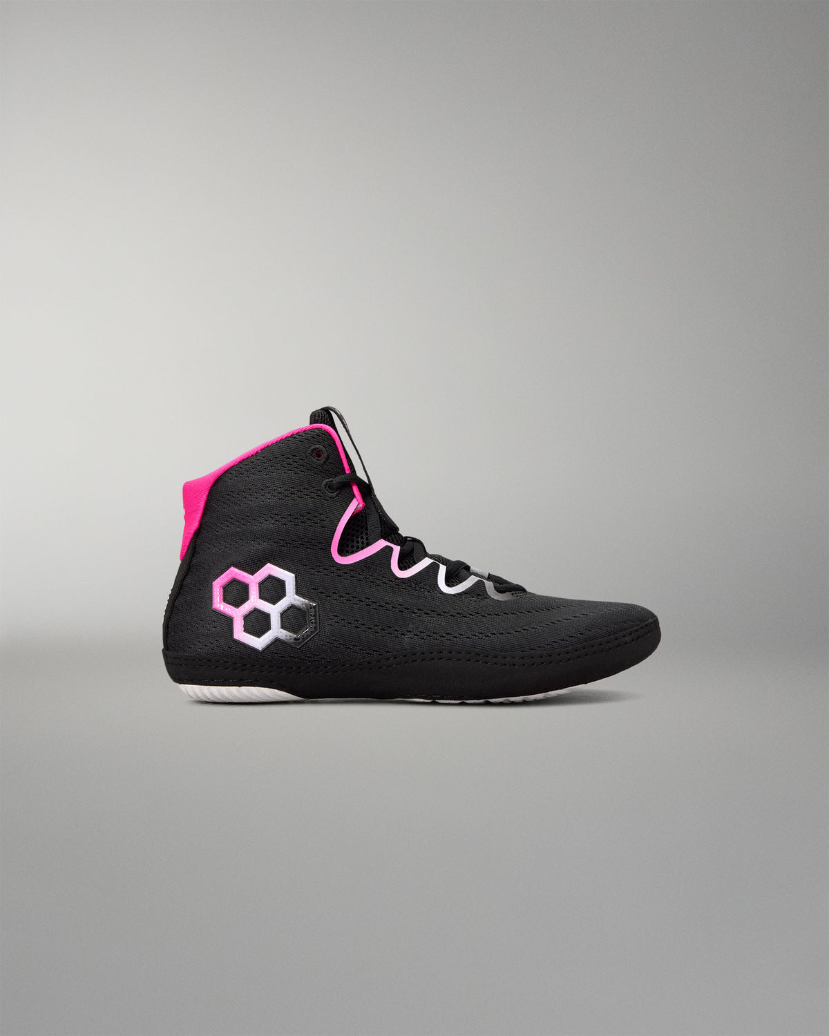 A black high-top wrestling shoe with bright pink accents, including a pink hexagonal logo on the side and a pink collar lining, shown against a neutral gray background.