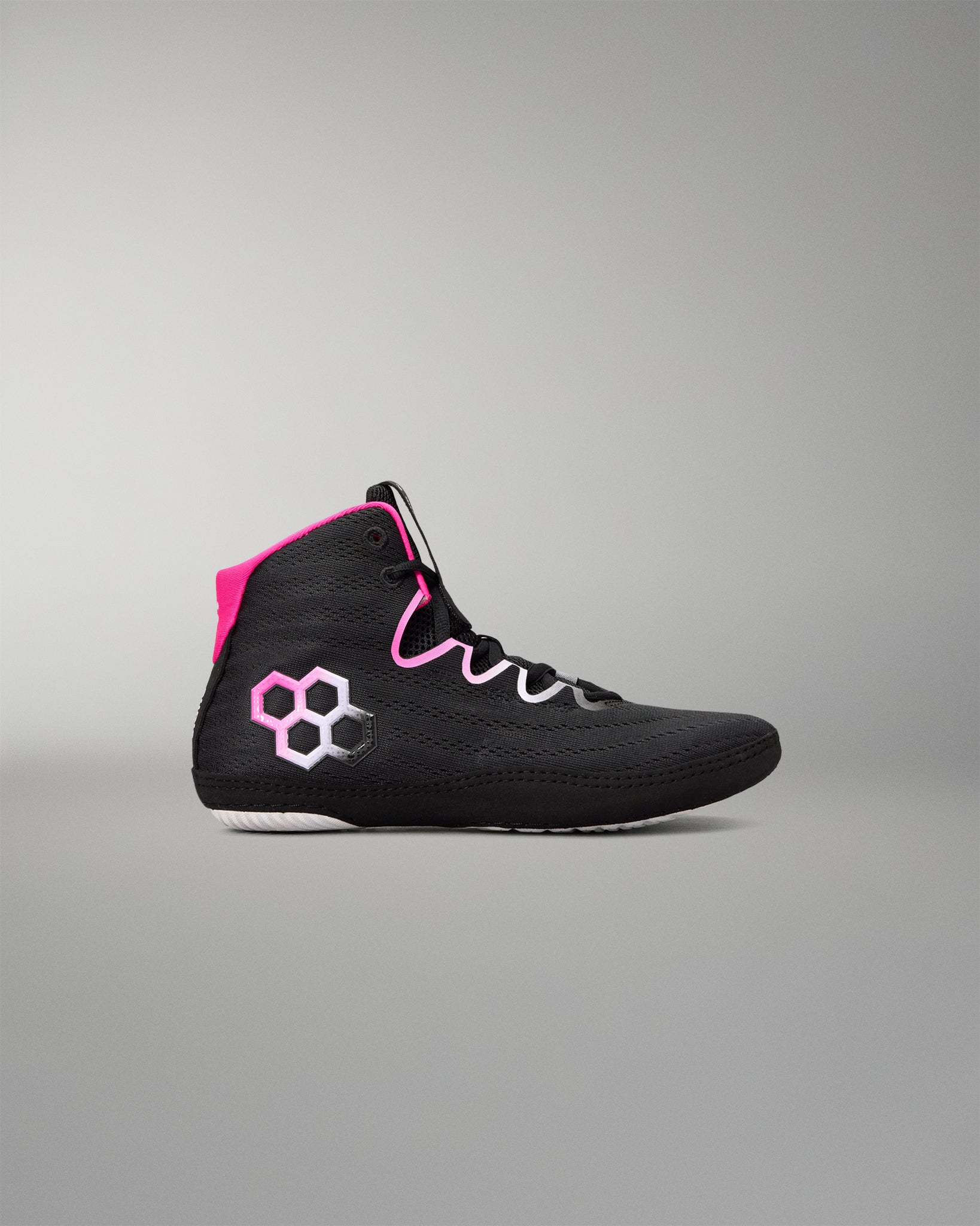 A black high-top wrestling shoe with bright pink accents, including a pink hexagonal logo on the side and a pink collar lining, shown against a neutral gray background.