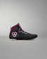 A black high-top wrestling shoe with bright pink accents, including a pink hexagonal logo on the side and a pink collar lining, shown against a neutral gray background.