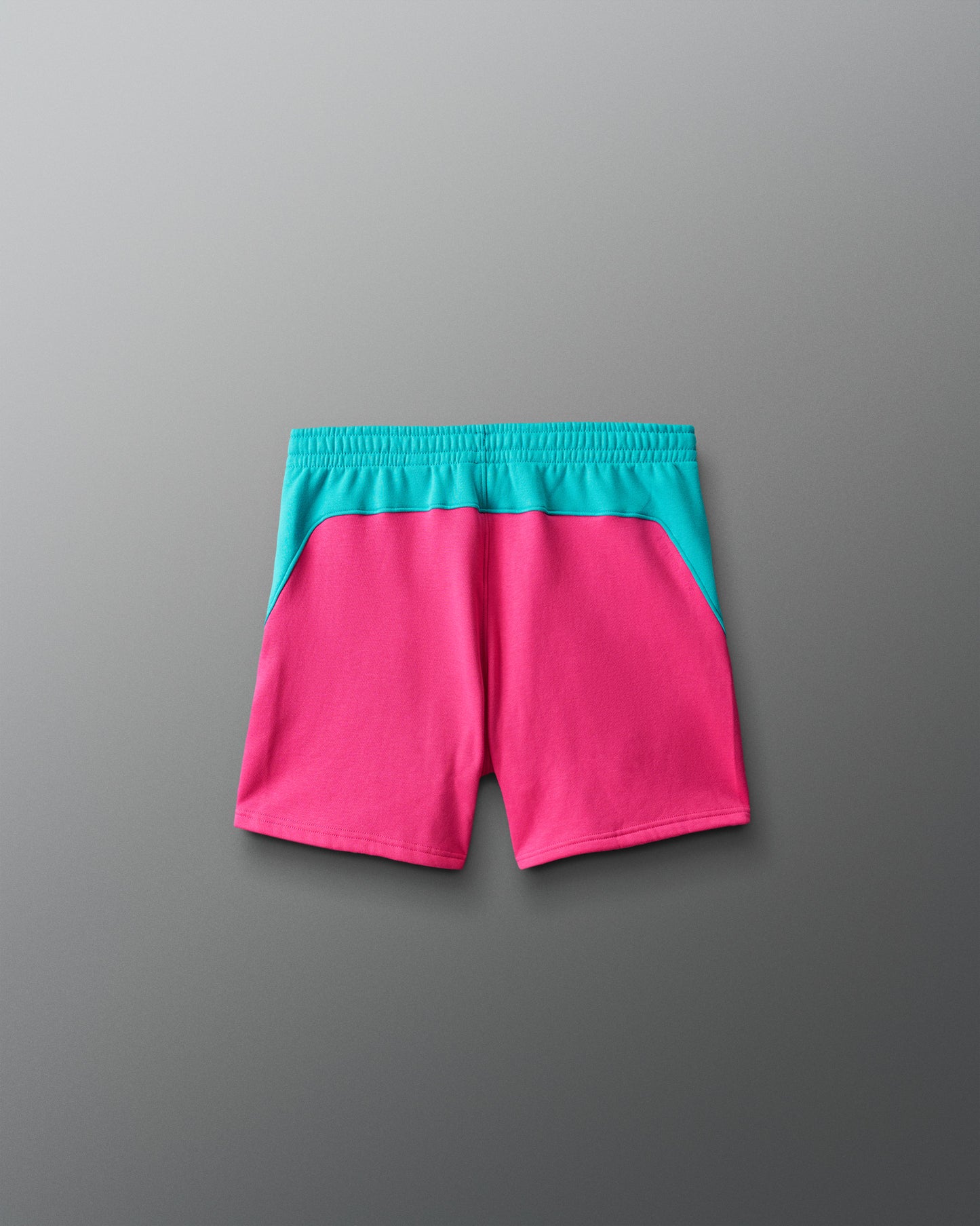 Pink shorts with teal waistband on a gray background