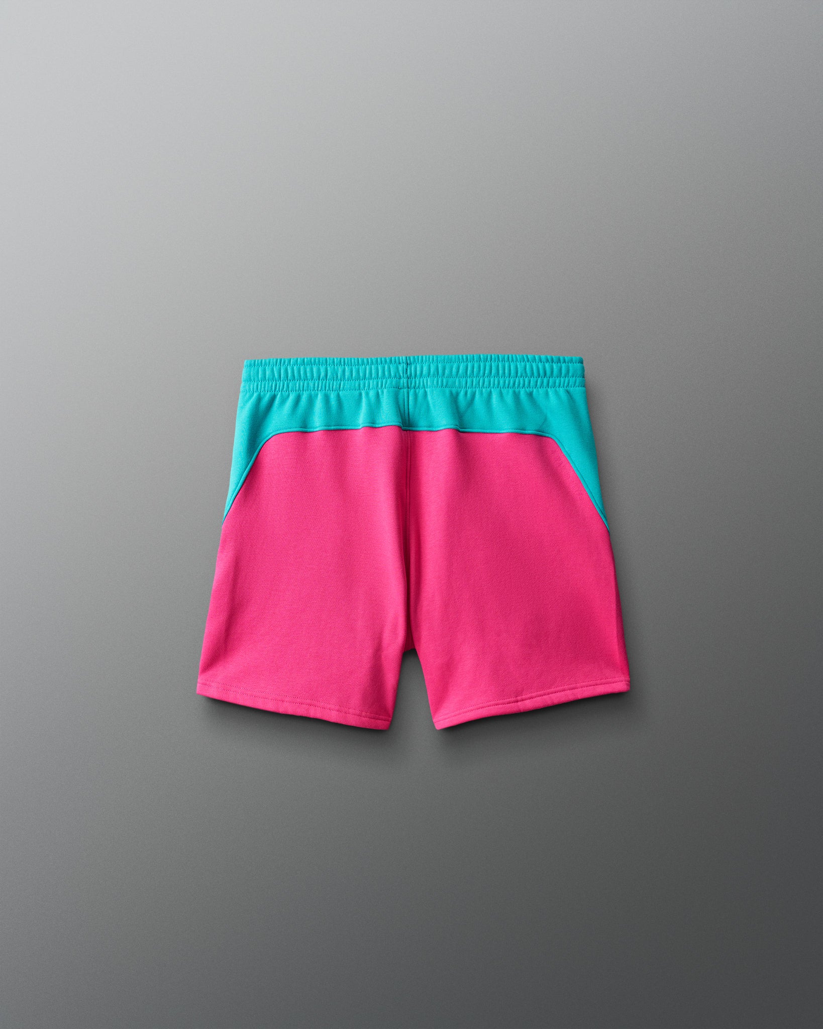 Pink shorts with teal waistband on a gray background