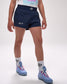 Person wearing navy shorts with 'All In' text, white socks, and blue sneakers on a white background