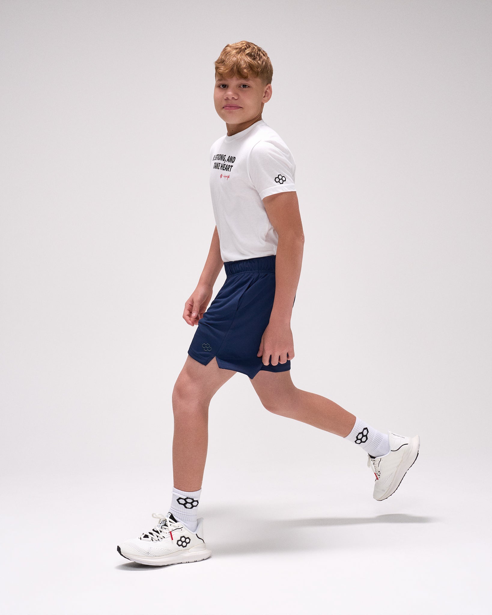 Person wearing a white t-shirt and navy shorts on a light gray background