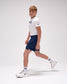 Person wearing a white t-shirt and navy shorts on a light gray background