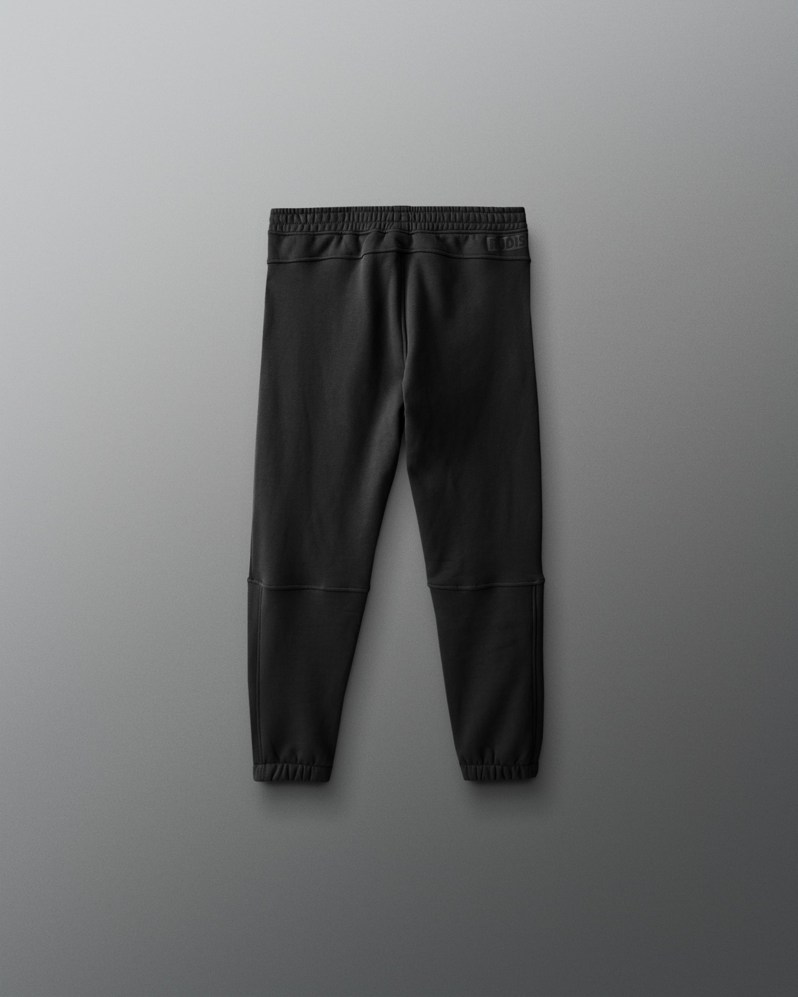 Black jogger pants on a gray background