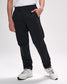 Person wearing black pants and white sneakers on a plain background