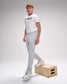 Person wearing a white t-shirt and gray pants standing on a wooden box against a plain background