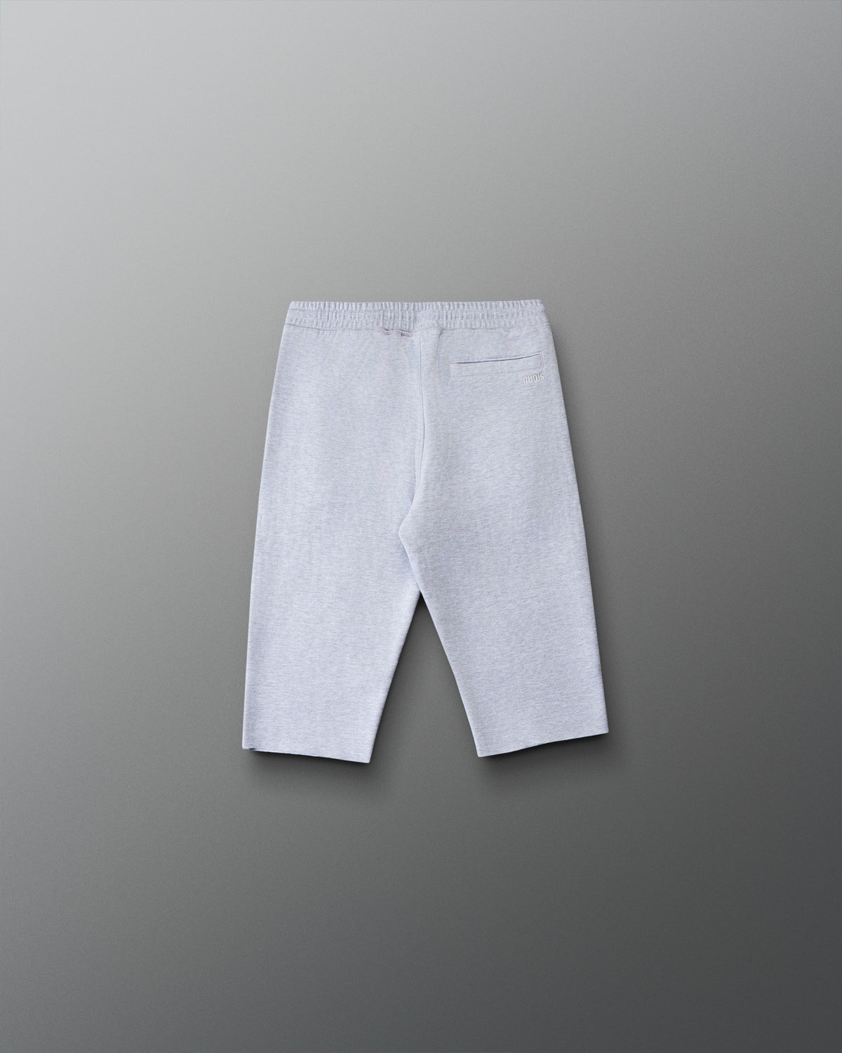 Back view of the RUDIS Youth Titan Heavyweight Cut-Off Sweatpants in heather gray featuring a rear pocket, subtle RUDIS branding, and raw-cut hems.
