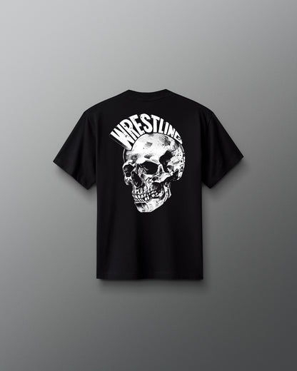 Back view of a black T-shirt featuring a large, detailed white skull graphic with the word ‘WRESTLING’ arched above it in bold, stylized letters.