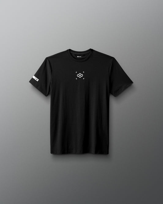 Black t-shirt with a small logo on a gray background