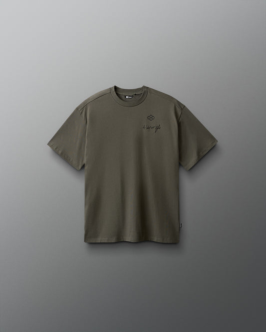 Green t-shirt with a small logo on a gray background