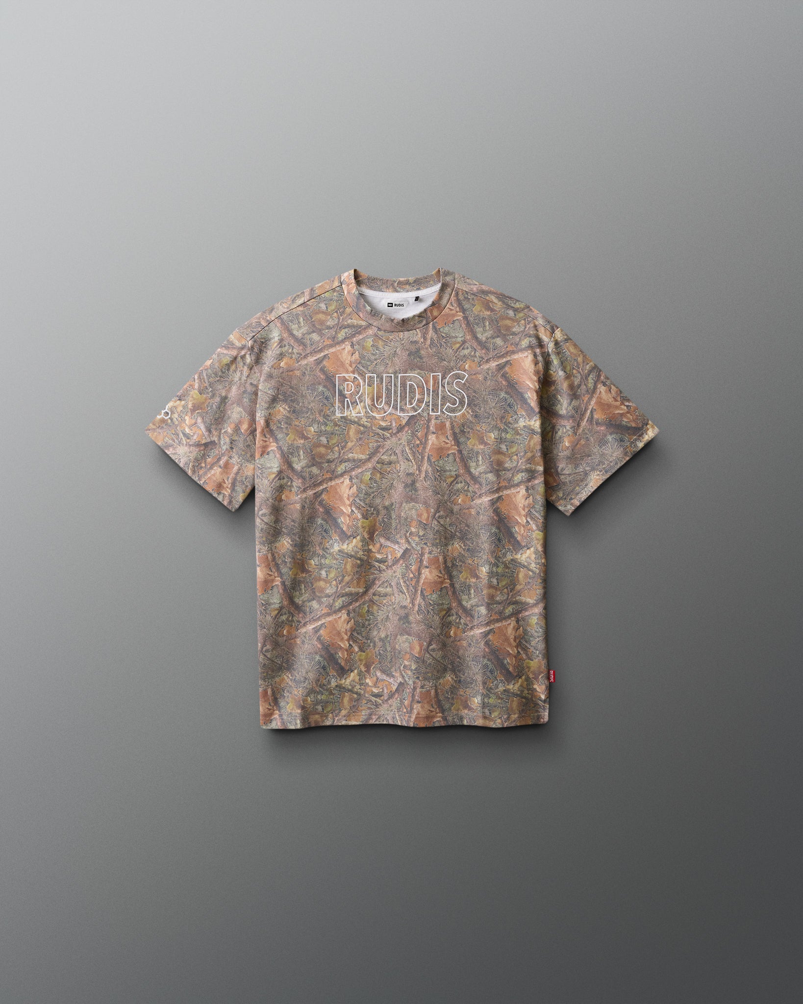 Camouflage-patterned t-shirt with 'RUDIS' branding on a gray background