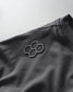 Close-up of a dark fabric with a geometric logo on a light gray background